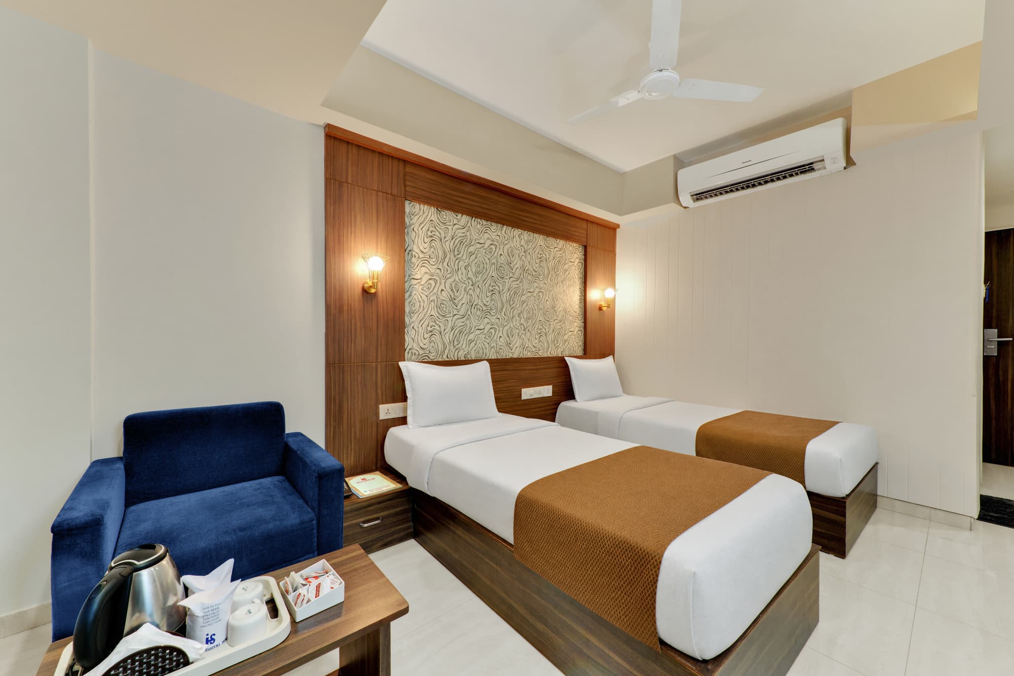 Hotel Shital Inn Deluxe Twin Bed Room with two beds and lounge chair